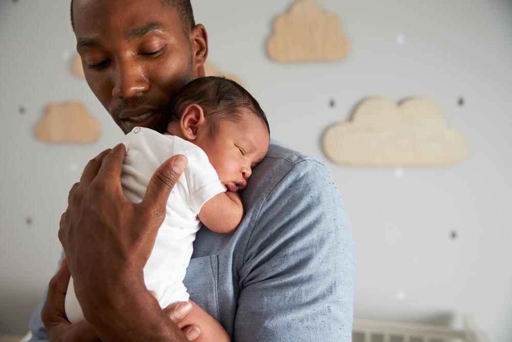 Baby sleeping in dad’s arms