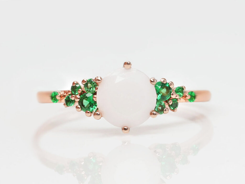 breastmilk jewelry rose gold ring with may emerald birth month color crystals gems on the sides of breastmilk central stone from keepsakemom