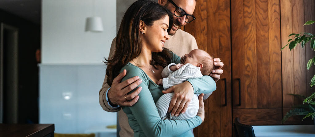 New parents cradling their baby