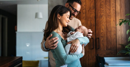 New parents cradling their baby