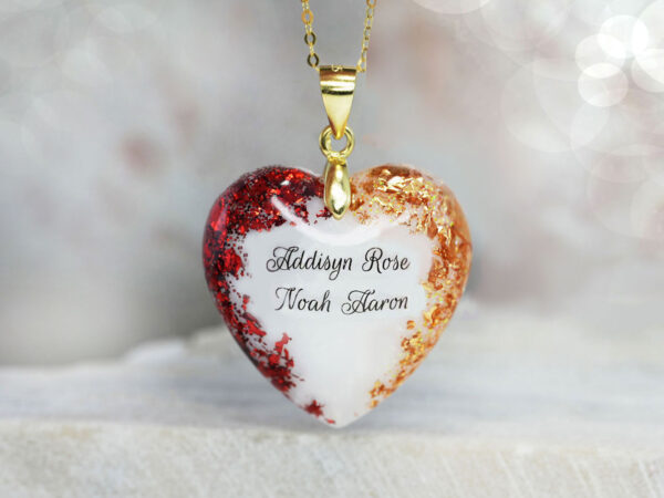 Breastmilk jewelry heart necklace celebrating two children with garnet red and november citrine yellow flakes, names, and gold chain and bail from KeepsakeMom and two red and yellow birth month flakes