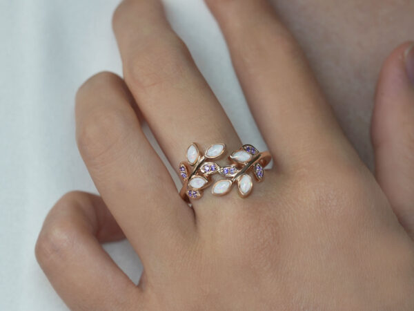 breastmilk jewelry ring on a model hand close-up in rose gold mother's embrace purple crystals leaves