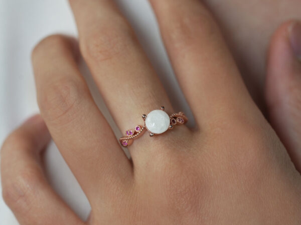 breastmilk jewelry ring on a model hand close-up in rose gold round pink stones