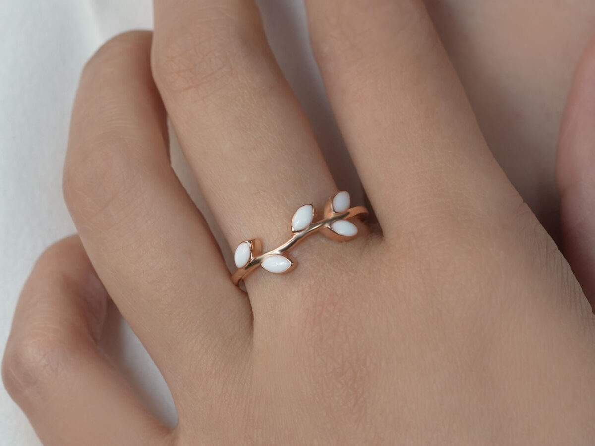 breastmilk jewelry ring on a model hand close-up in rose gold leaves branch