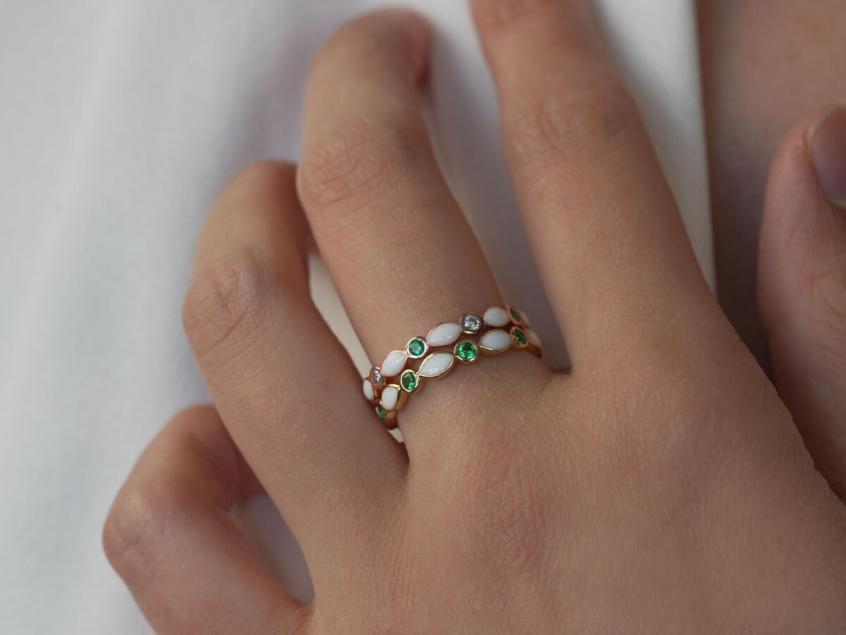breastmilk jewelry ring on a model hand close-up in rose gold with crystals of birth color marquise style two rings