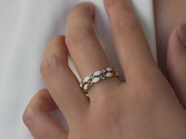 breastmilk jewelry ring on a model hand close-up in rose gold with crystals of birth color marquise style two rings