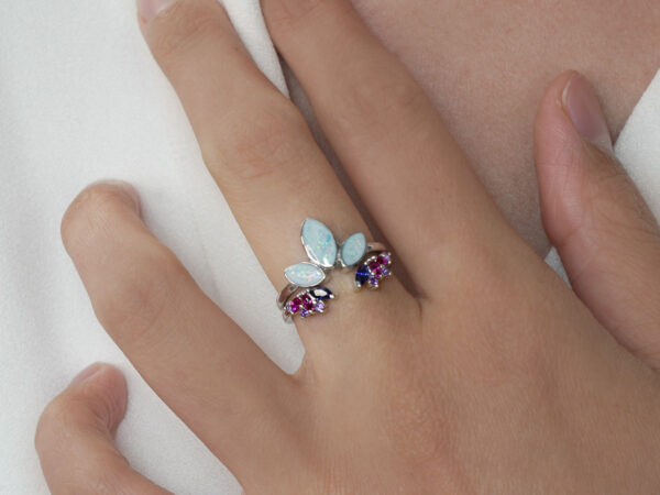 breastmilk jewelry ring set on a model hand with two rings lotus and emerald gems from keepsakemom