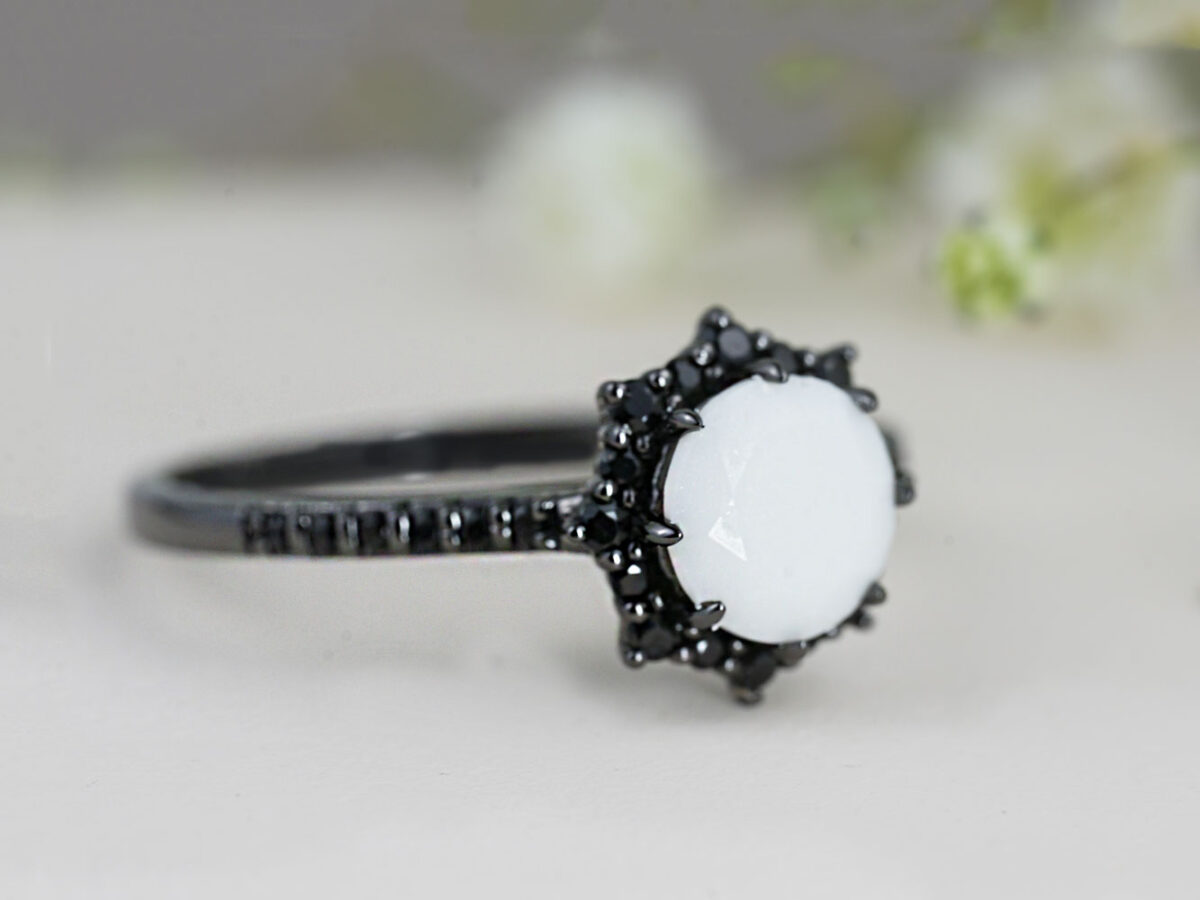 breastmilk ring in rare black flower shaped setting rhodium or black gold with central breast milk stone in shape of diamond and clear diamonds birth month color gems and stones on a band from keepsakemom