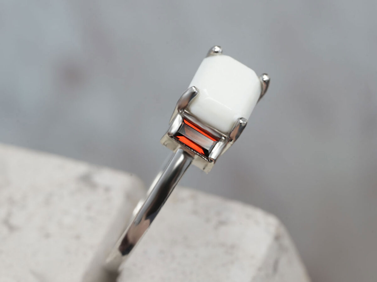 breastmilk ring with rectangular stone and rectangular birth month garnet red crystals on each side in sterling silver band from keepsakemom side view diagonal