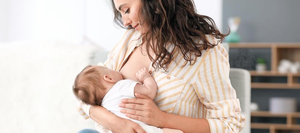Baby feeding from one breast