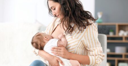 Baby feeding from one breast