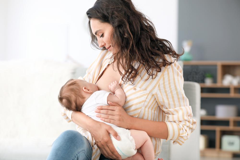 Baby feeding from one breast