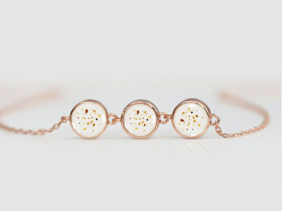 breastmilk bracelet with three small discs filled with breast milk and brown specks of placenta and umbilical cord in rose gold setting from keepsakemom