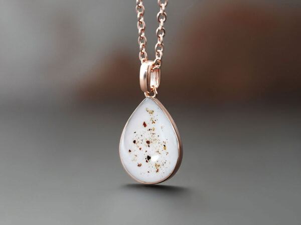 breastmilk jewelry necklace teardrop shaped in rose gold with brown color specks of placenta and umbilical cord from keepsakemom