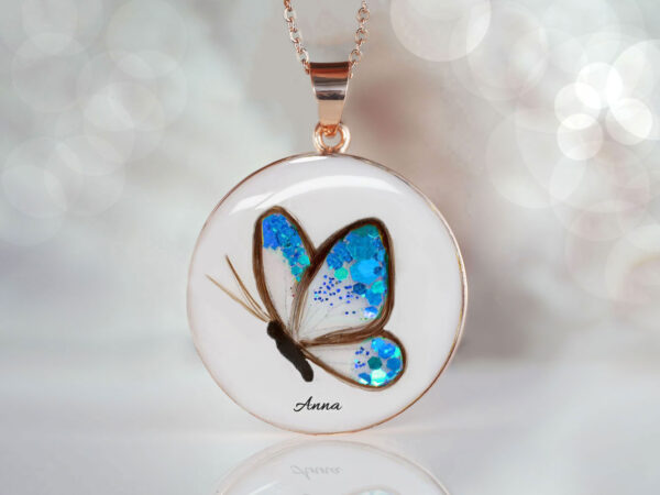 Breastmilk jewelry memorial disc necklace with butterfly made with child's or babies hair, blue birth color flake filling the wings, name and yellow gold chain and bail from KeepsakeMom