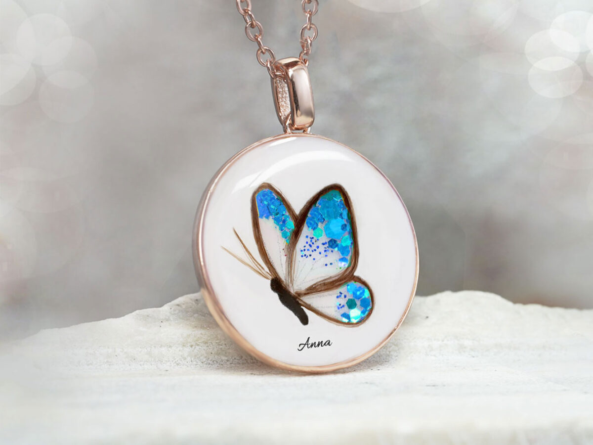 Breastmilk jewelry disc memorial necklace with butterfly made with child's or babies hair, blue birth color flake filling the wings, name and yellow gold chain and bail from KeepsakeMom