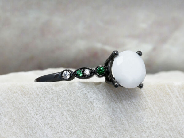 breastmilk ring in rare black setting rhodium or black gold with central breast milk stone in shape of faceted diamond and green and clear birth month color gems and stones on a band from keepsakemom