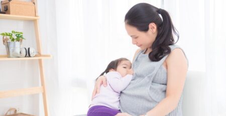 Pregnant mother nursing her toddler