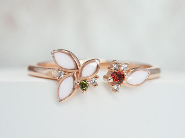 breastmilk ring with four breastmilk filled leaves and red and green crystal gems in rose gold on white background from keepsakemom