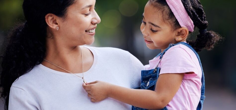A daughter admiring her mother’s necklace