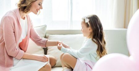 A daughter looking at her mom’s bracelet. 