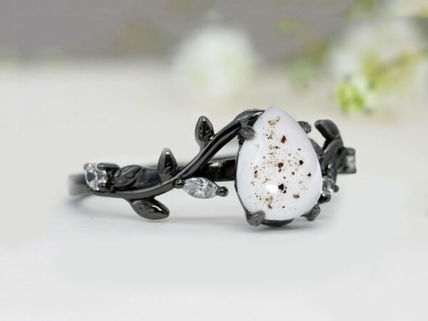 memorial ring in black gold or rhodium in branch shape with drop like shape stone made with breastmilk and sprinkled with ashes