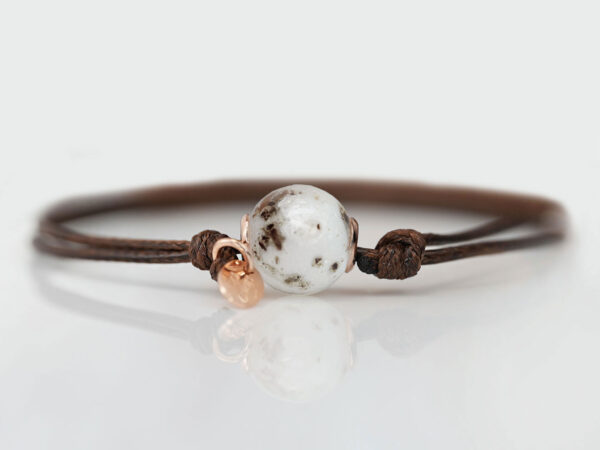 cremation jewelry bracelet with a pearl filled with breastmilk and ashes on brown waxed cord from keepsakemom