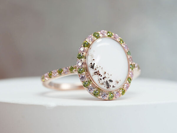 memorial cremation ring with oval breastmilk stone with ashes, milk and lock of hair adorned with pink and peridot green crystals in gold filled with breastmilk and ashes and lock of hair from keepsakemom
