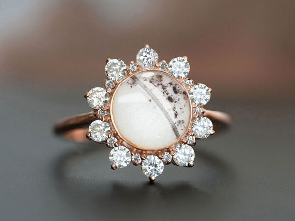 memorial cremation ring with round breastmilk stone with ashes, milk and lock of hair adorned with clear crystals and purple tiny crystals in gold filled with breastmilk and ashes and lock of hair from keepsakemom