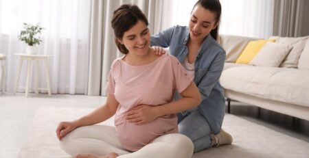 A doula working with a pregnant woman in the living room