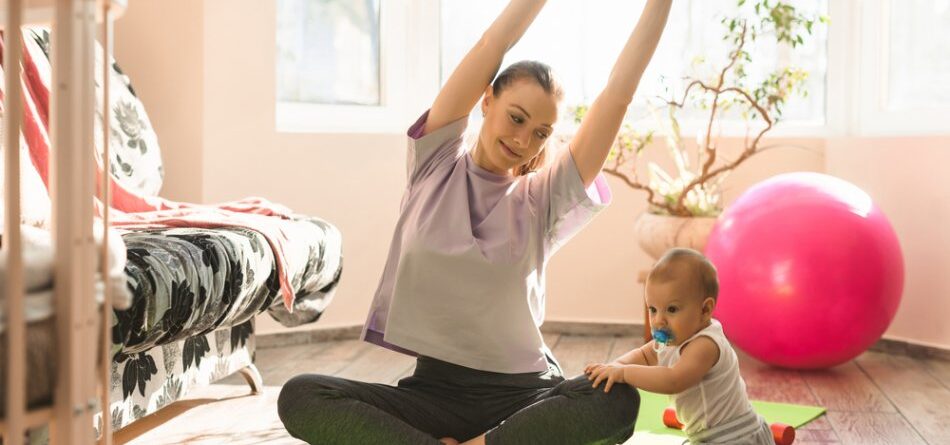 A mother doing yoga while watching her baby
