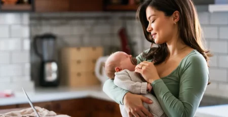 A fashionable mom working from home and taking care of her baby