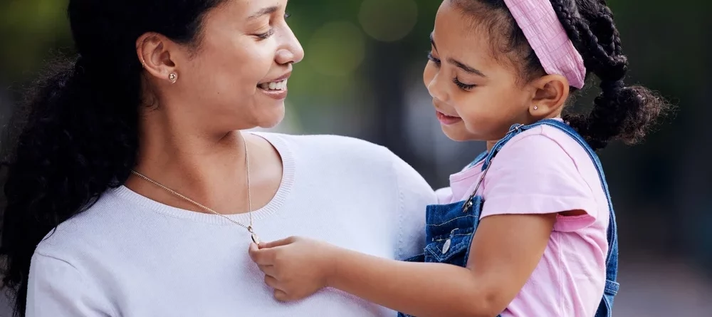 A daughter admiring her mom’s necklace