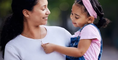 A daughter admiring her mom’s necklace